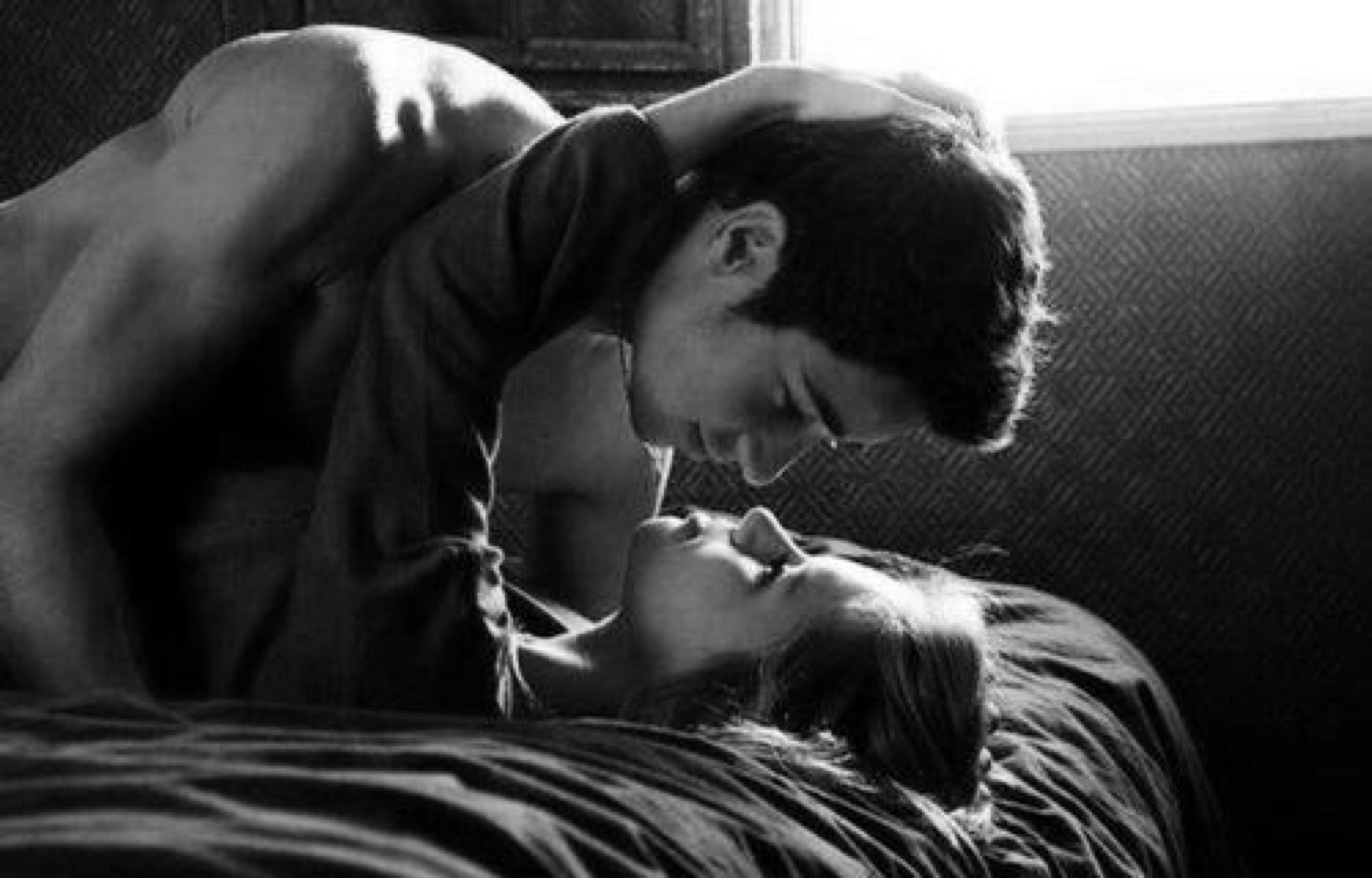 Парень целует девушку в кровати