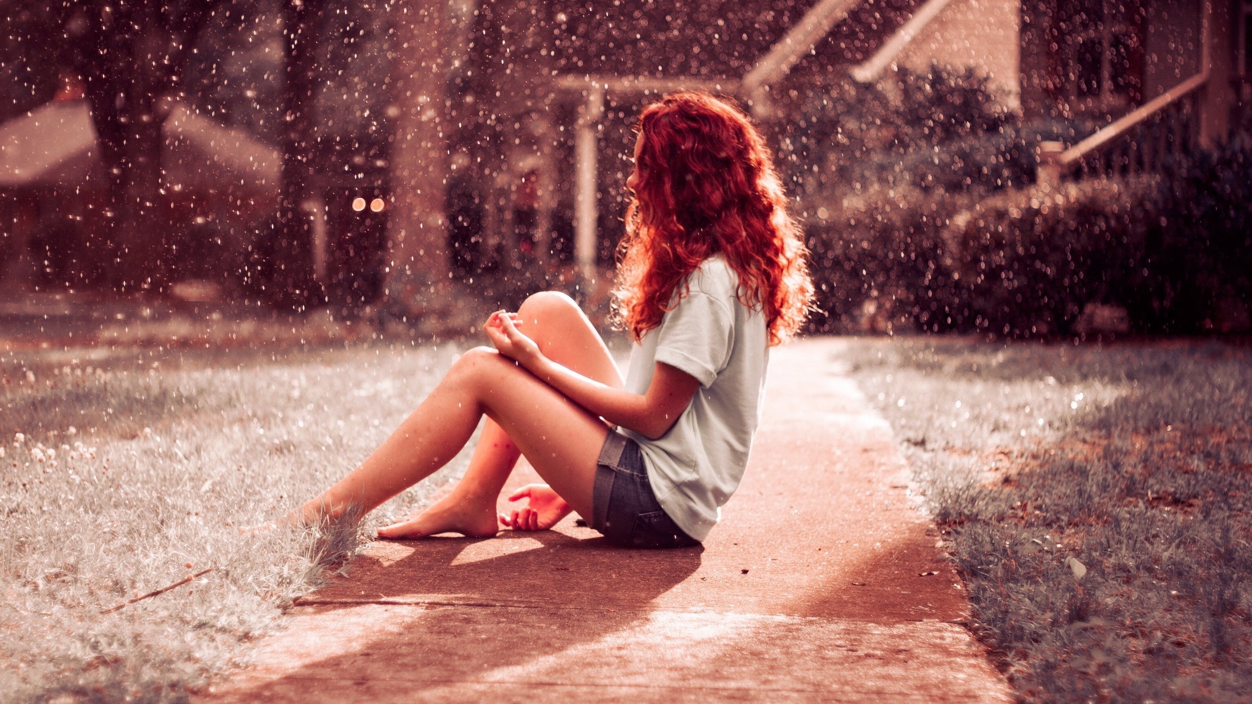 Девушка сидит под дождем